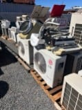Old air conditioner units stacked on pallets